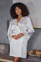 Load image into Gallery viewer, The Ivory Deia robe is knee length made in beautiful heavy-weight pure silk satin. It is belted at the waist with a side pocket.

Tone on tone Calais lace appliqué on the shoulder and sleeves gives additional femininity to the stunning robe. Essential for those who love quality and refined, timeless style.
