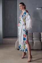 Load image into Gallery viewer, Beryl Full length robe. 
A fabulous floral pattern with an embroidered rendering. Entirely made of mixed silk satin, with a floral print on an ivory background, it seduces with its fluid and majestic look.
The pattern, both poetic and bright, evokes the refinement of watercolor embroidery, in a palette of deep and vibrant shades.
The cut is straight, loose, crossed at the front. The waist is accentuated by a matching belt with decorative long fringe. The wide sleeves, also enhanced with silky fringe.
