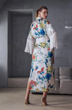 Load image into Gallery viewer, Beryl Full length robe. 
A fabulous floral pattern with an embroidered rendering. Entirely made of mixed silk satin, with a floral print on an ivory background, it seduces with its fluid and majestic look.
The pattern, both poetic and bright, evokes the refinement of watercolor embroidery, in a palette of deep and vibrant shades.
The cut is straight, loose, crossed at the front. The waist is accentuated by a matching belt with decorative long fringe. The wide sleeves, also enhanced with silky fringe.
