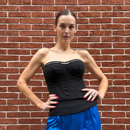 This is the most beautiful twill corset 
Cadolle. The tailcoat detail accentuates the waist to perfection and can be worn as a statement top.

The structure flatters your shape and creates a beautiful bust. The zipper is placed on the back. Running along your hip is a wide band, flaring out in the back, just like a tail coat. Its design was inspired by conductors leading the orchestra.
