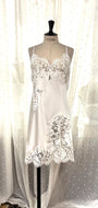 Made in Florence, this is a beautiful pure silk satin slip or nightgown. There is stunning deep appliqué lace on the bust. A side wide lace split leads from the thigh to the hem, continuing all around the base of the garment.  There are French seams throughout for softness. The fine spaghetti straps are adjustable for the perfect fit. This nightslip is cut on the bias and panelled, giving a lovely flare and movement. May be worn as underwear, nightwear or outerwear. Ivory.