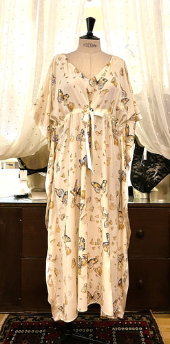 A beautiful, loose fitting pure silk Kaftan. The satin finish of the silk is on the inside, giving a sensuous sensation against the skin. The outside has a stunning butterfly print on a butter cream silk ground. There is a drawstring detail under the bust to allow for an individual fit. This is a striking garment. It is perfect for home, or as outerwear, beach or cruise wear.  One Size. Fabric: Printed Pure Silk  Made in France.