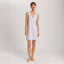 Load image into Gallery viewer, A woman wearing a Pink Lavender sleeveless short (knee length) nightdress. The deep V-neck is adorned with a wide embroidered lace trim on tulle. The garment has a lovely feminine flow to it.

