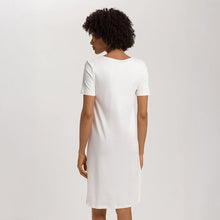 Load image into Gallery viewer, Image of the back of a woman wearing an Off White short (knee length) nightdress with short sleeves. The garment has a lovely feminine flow to it.
