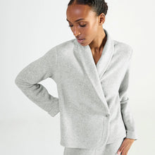 Load image into Gallery viewer, A woman wearing a light gray heathered shawl collar wrap bed jacket with a single button closure, photographed against a clean white studio background.
