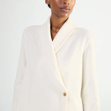 Load image into Gallery viewer, A close-up of a model wearing a cream-colored shawl collar wrap bed jacket with a single button, set against a plain white studio background.
