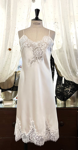 Butter/Ivory. Made in Italy, this is a beautiful long pure silk satin night/slip. There is stunning deep appliqué lace at the bust and hem. There are French seams throughout for softness. The fine spaghetti straps are adjustable for the perfect fit. This nightslip is cut on the bias and panelled giving lovely flare and movement. Perfect for bed or daywear. May be worn as underwear, nightwear or outerwear.   Composition: 100% Silk Satin Italian Lace 100% polyamide Machine washable Length 82cm from nape.