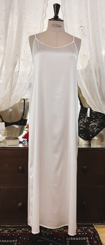 Ivory simple, plain & classic, full length silk satin nightgown. Made from 92% silk satin and with a little Elastane for stretch and movement.  Adjustable spaghetti straps with a rounded neckline and all French seams for softness when wearing. The skirt is full length with a back slit. This garment is perfect for sleepwear or as a long slip under clothing. Generous sizing, if in doubt select the smaller size.  Oscalito Silk is Certified GOTs  Fabric Content: 92% Silk 8% Elastane