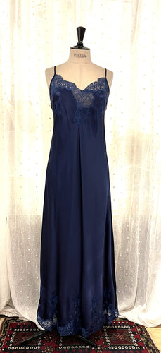 Made in Florence, this is a beautiful pure silk satin full length nightgown. There is stunning deep appliqué lace on the bust. A side wide lace split leads from the thigh to the hem, continuing all around the base of the garment.  It has French seams throughout and adjustable spaghetti straps. It is cut on the bias and panelled, giving a lovely flare and movement. May be worn as underwear, nightwear or outerwear. Generously cut. 130cm length.