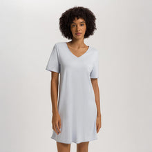 Load image into Gallery viewer, A woman wearing a Powder Blue short sleeve cotton silk above knee length 90 cm long nightdress. It has a silk trim on the V-neck as well as on the sleeves and the hem. 
