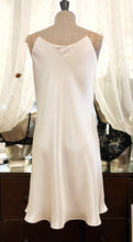 Load image into Gallery viewer, Ivory/Ecru. Classic, short night/slip. Made from 100% silk satin. The wide lace straps have a gentle elasticity for fit and comfort.  Appliqué lace detail continues to the round neck. Cut on the bias for movement and swing. This garment is perfect for sleepwear or loungewear. Generous sizing, if in doubt select the smaller size.   100% Silk Satin. Lace: 78% Nylon, 16% Elastane, 6% Polyester. Made in Italy. Machine washable.
