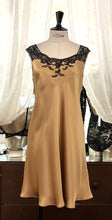 Load image into Gallery viewer, Camel/Black. Classic, short night/slip. Made from 100% silk satin. The wide lace straps have a gentle elasticity for fit and comfort.  Appliqué lace detail continues to the round neck. Cut on the bias for movement and swing. This garment is perfect for sleepwear or loungewear. Generous sizing, if in doubt select the smaller size.   100% Silk Satin. Lace: 78% Nylon, 16% Elastane, 6% Polyester. Made in Italy. Machine washable.
