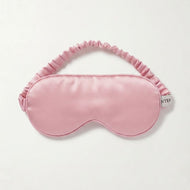 A light pink Pure silk satin sleep mask with a matching ruffled elastic strap, displayed flat against a clean off-white background.