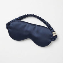Load image into Gallery viewer, A navy blue pure silk satin sleep mask with an elasticized strap, shown on a clean white background. A small white tag on the side of the mask displays the brand name 'SISTER'.
