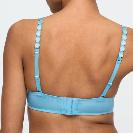 Light blue bra with thin straps on a neutral background