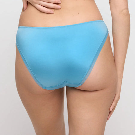 Blue underwear worn by a person on a plain background