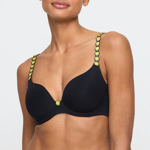 Black bra with smiley face straps worn by a model on a white background