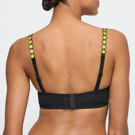 Black bra with green straps featuring smiley face designs on a plain background