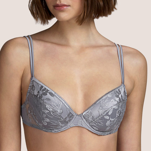 This is a beautiful, moulded embroidered plunge bra. The inside of the cup has a satin lining for smoothness against the skin. There is a removal pad giving the option of two different presentations. The fine double strap offers delicacy with strength.  Andres Sarda is famous for its innovation in its use of fabrics. Tina in Metallic Silver is a perfect example.  Fabric content: Polyester: 74%, Cotton: 13%, Polyamide: 9%, Elastane: 4%