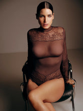 Load image into Gallery viewer, Woman wearing a sheer brown lace bodysuit sitting on a chair against a plain background
