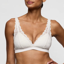 Load image into Gallery viewer, White lace bra worn by a model on a plain background
