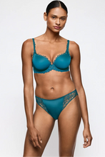 Load image into Gallery viewer, A model wearing a teal blue lace bra and matching lace panties against a plain light gray studio background.
