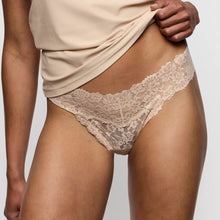 Load image into Gallery viewer, Beige lace underwear being worn against a neutral background
