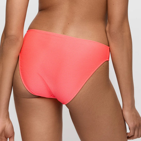Person wearing a bright pink bikini bottom on a plain background