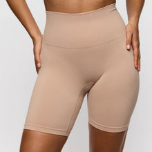 Load image into Gallery viewer, Beige high-waisted shorts worn by a person on a light gray background
