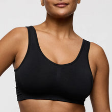 Load image into Gallery viewer, Black sports bra worn by a person on a light gray background
