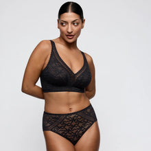 Load image into Gallery viewer, Woman wearing black lace lingerie on a plain background
