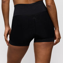 Load image into Gallery viewer, Black athletic shorts worn by a person on a plain background
