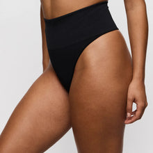 Load image into Gallery viewer, Person wearing black high-waisted bikini bottoms on a plain background
