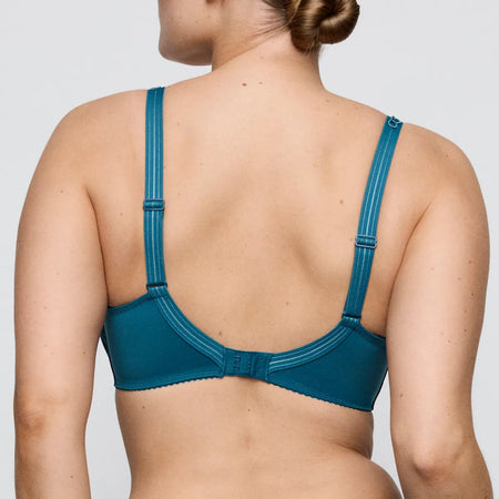 Blue bra worn by a person on a plain background