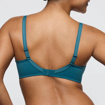 Teal bra worn by a model on a plain background