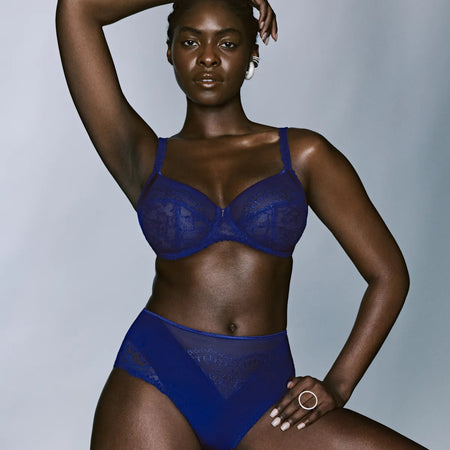 Woman wearing a blue lingerie set against a gray background