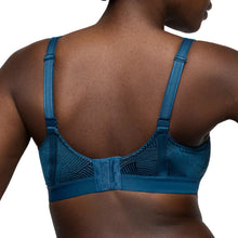 Load image into Gallery viewer, Blue sports bra worn by a person on a white background
