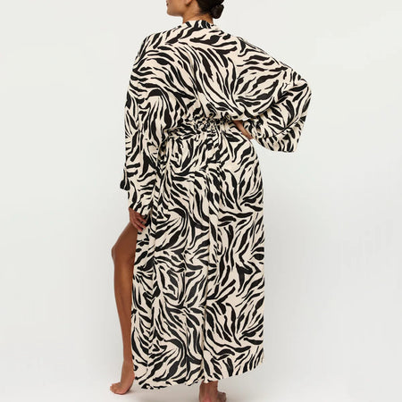 Person wearing a zebra print robe on a white background