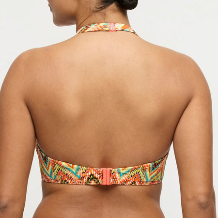 Multicolored bikini top worn by a person on a plain background