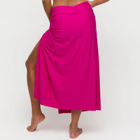 Person wearing a bright pink skirt on a white background