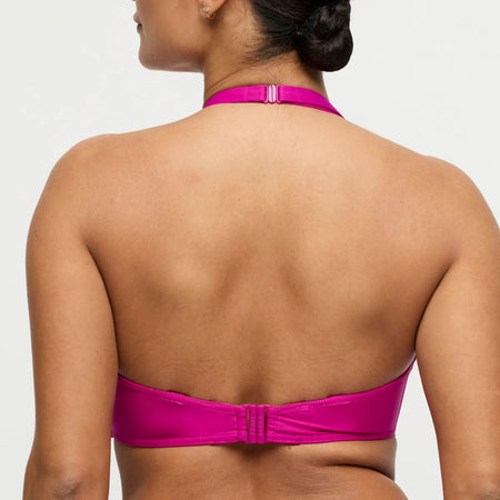 Person wearing a pink bikini top on a plain background