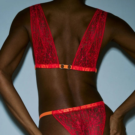 Red lace lingerie set on a model against a light blue background