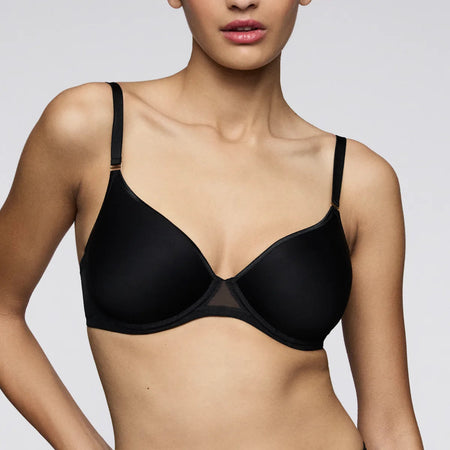 Black bra worn by a model on a plain background
