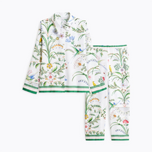 Load image into Gallery viewer, A two-piece pajama set featuring a long-sleeve button-up shirt and matching pants, both printed with a colorful botanical and bird pattern on a white background, finished with green striped trim.
