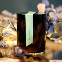 Load image into Gallery viewer, Brown jar with a green label on a decorative background
