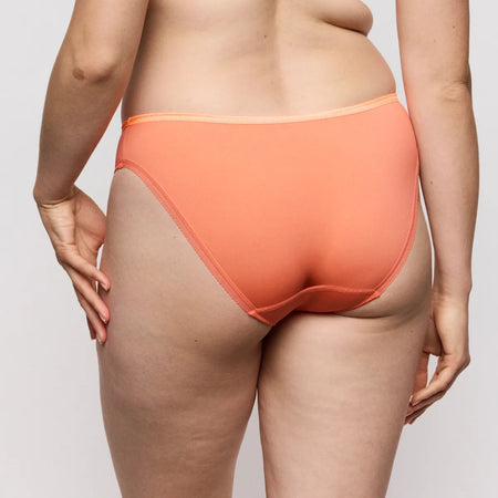 Person wearing orange underwear on a plain background