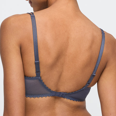 Navy blue bra on a model against a light gray background