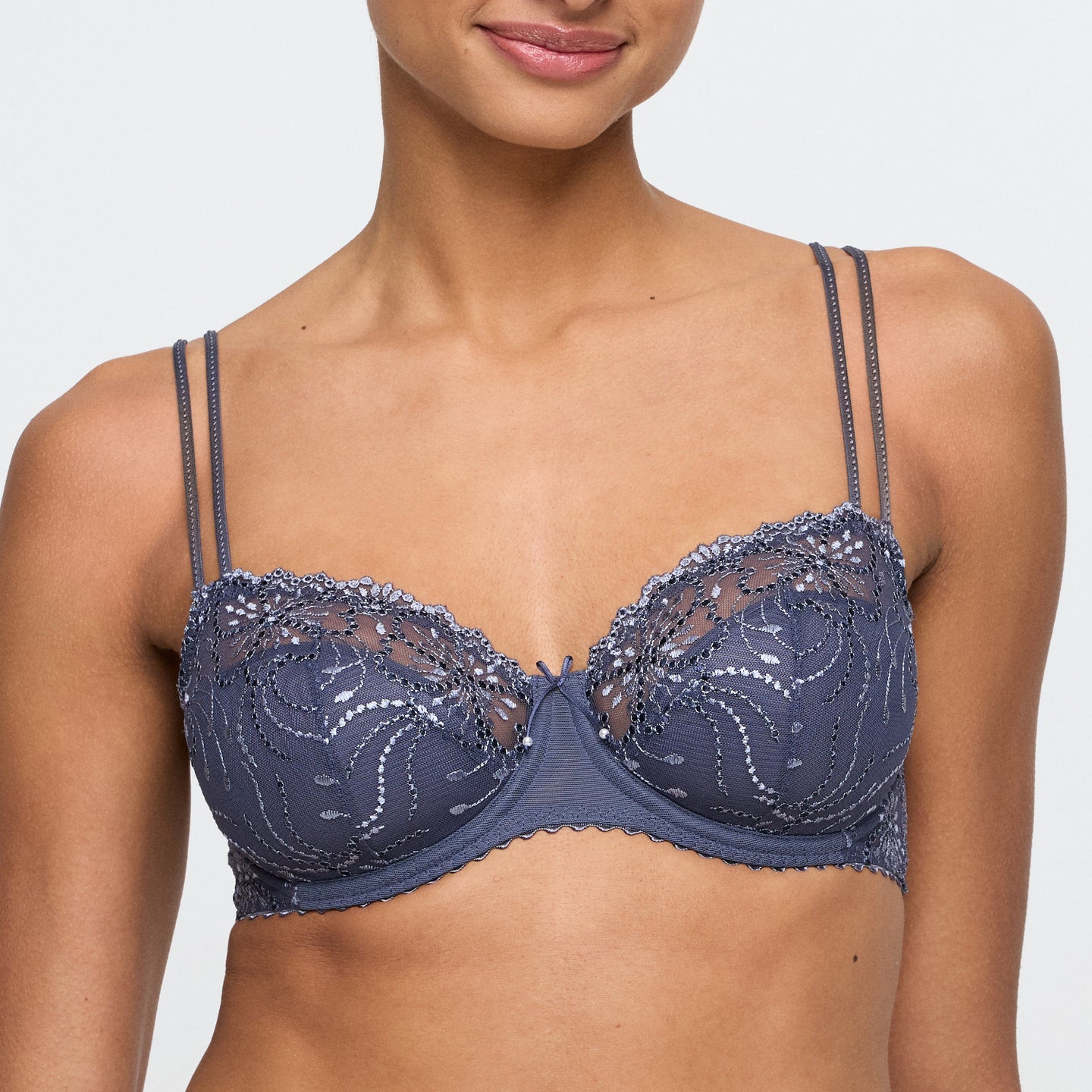Navy blue lace bra on a model against a plain background
