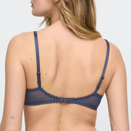 Navy blue bra worn by a model on a light gray background