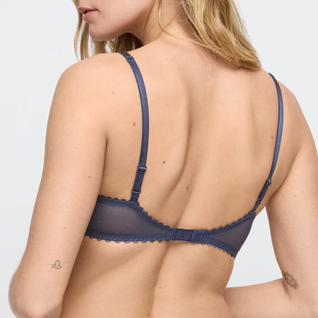 Navy blue bra worn by a model on a light gray background